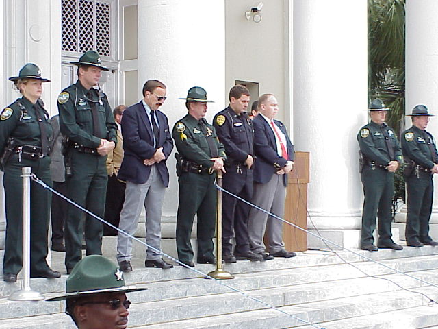 several police officers line up on the steps to speak to one another