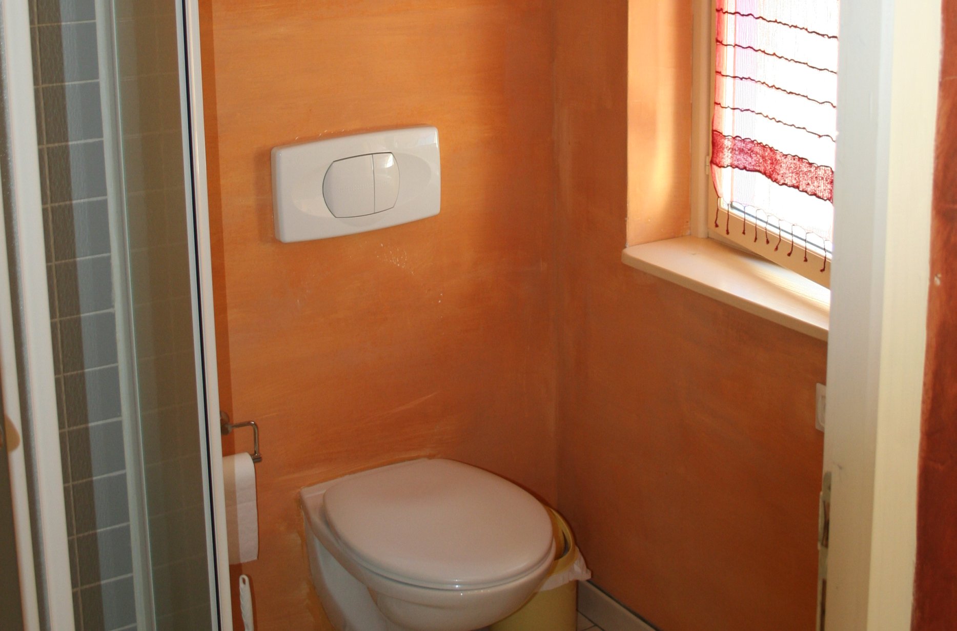 a clean bathroom with a small window and toilet