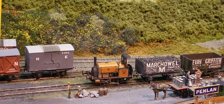 model train yard with a few cars and people working on the track