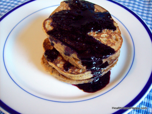 pancakes sitting on top of a blue and white plate covered in syrup