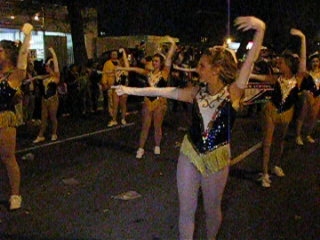 a parade with dancers on the street at night