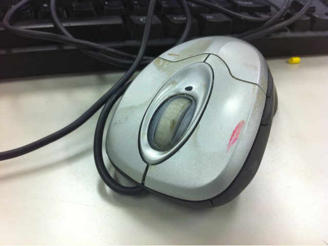 a computer mouse on the counter with cables running above it