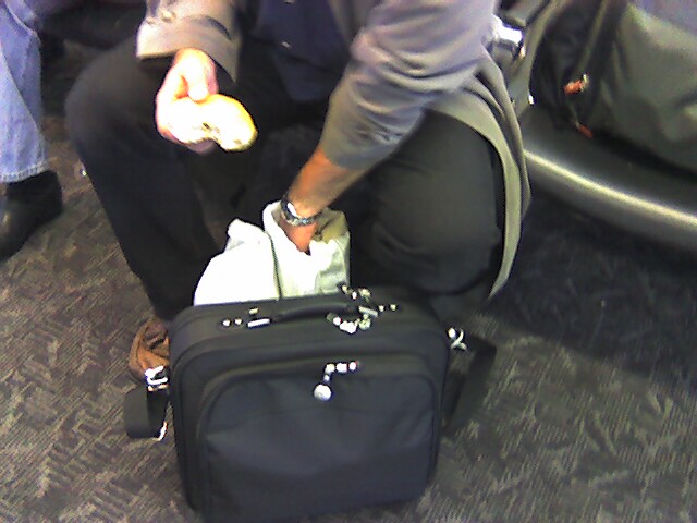 a man kneeling down on the floor in front of a suitcase with an object in it
