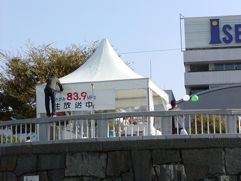 a crowd of people standing near a sign and tall building