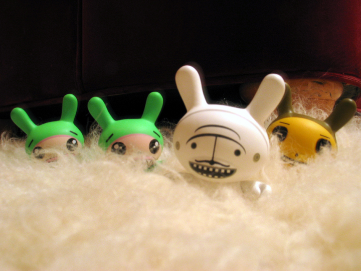 two rabbit dolls with green ears, sitting next to each other
