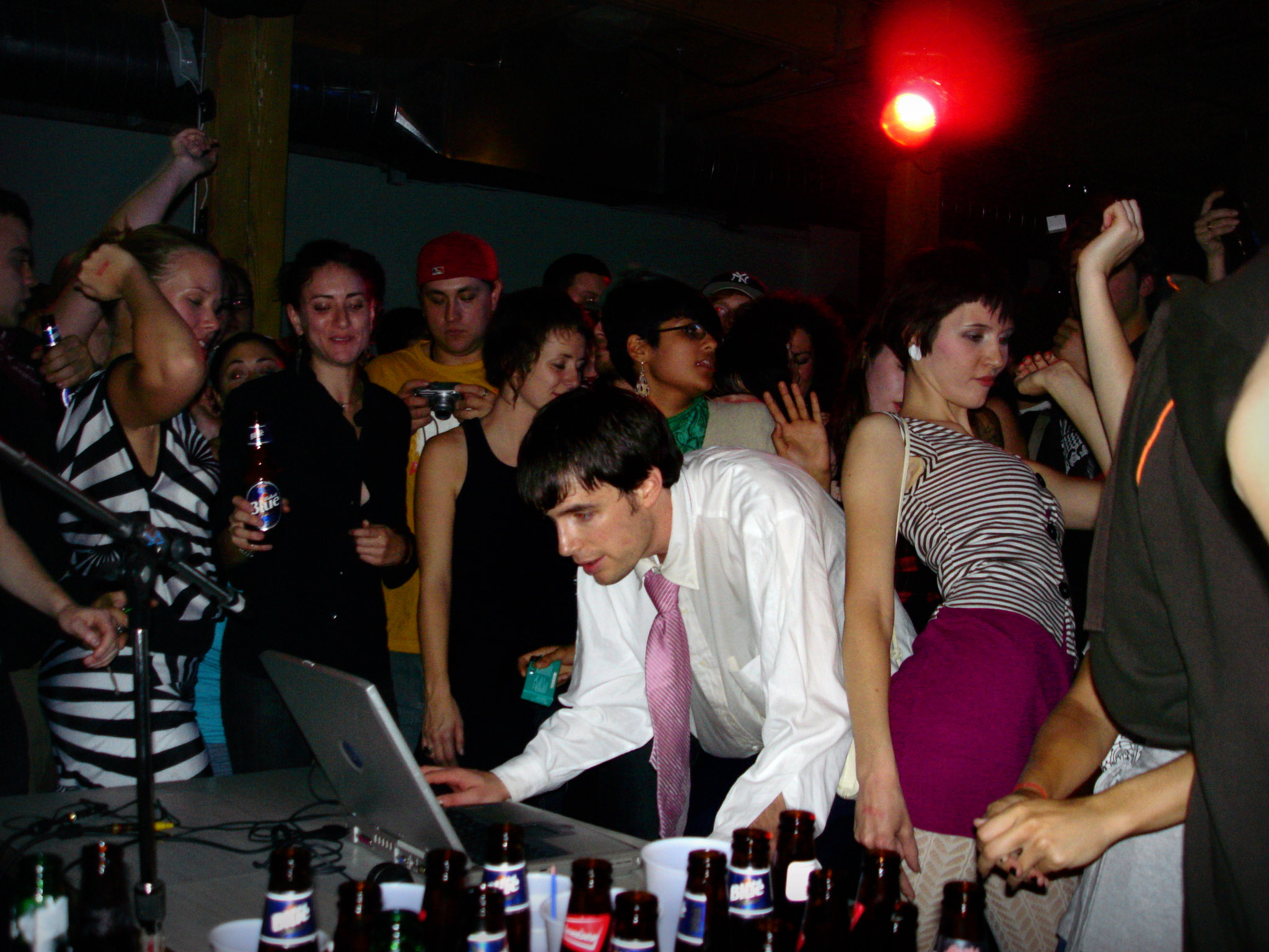 a man in suit and tie looking at laptop in front of people