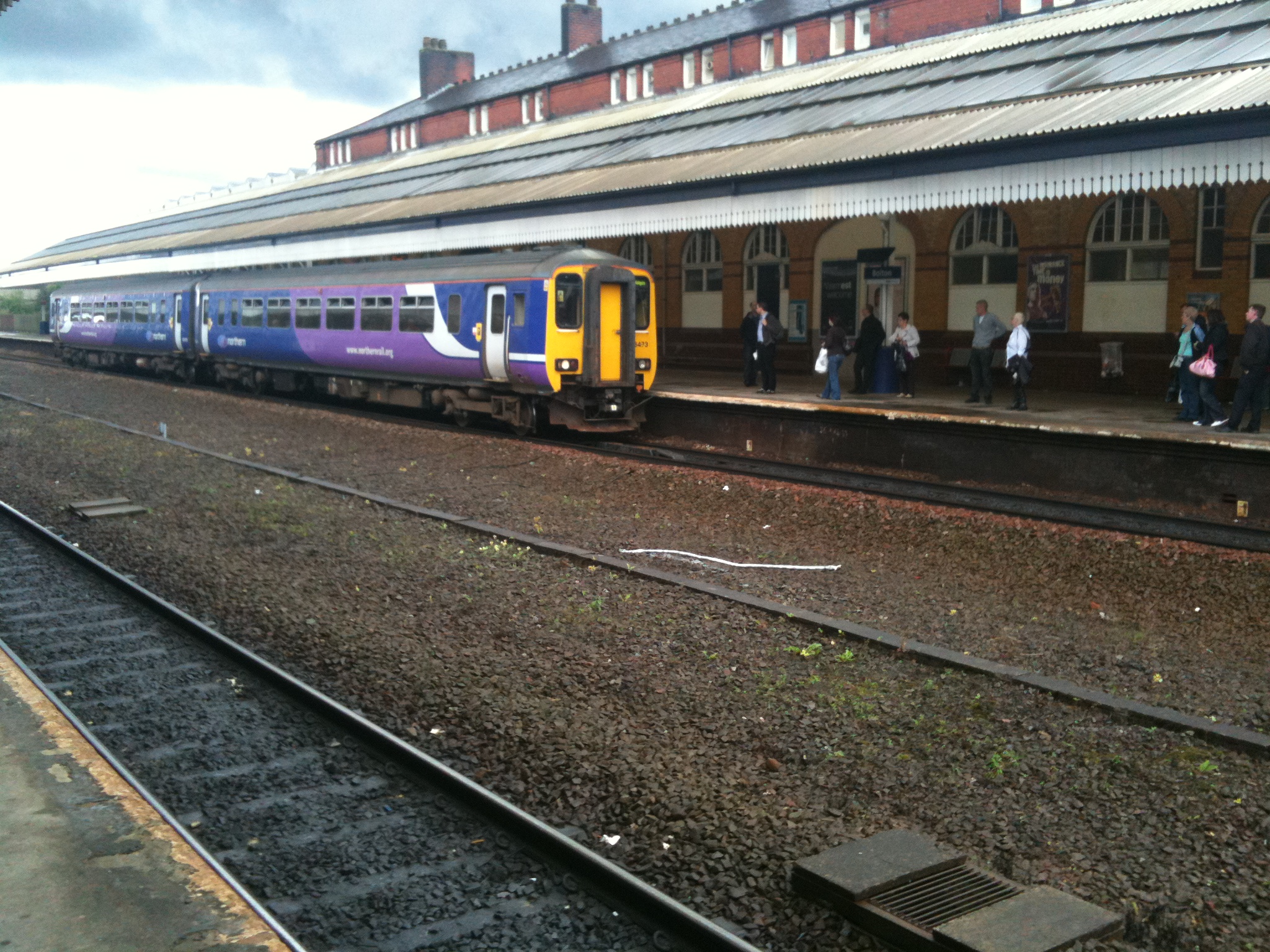 several people board a train on the tracks