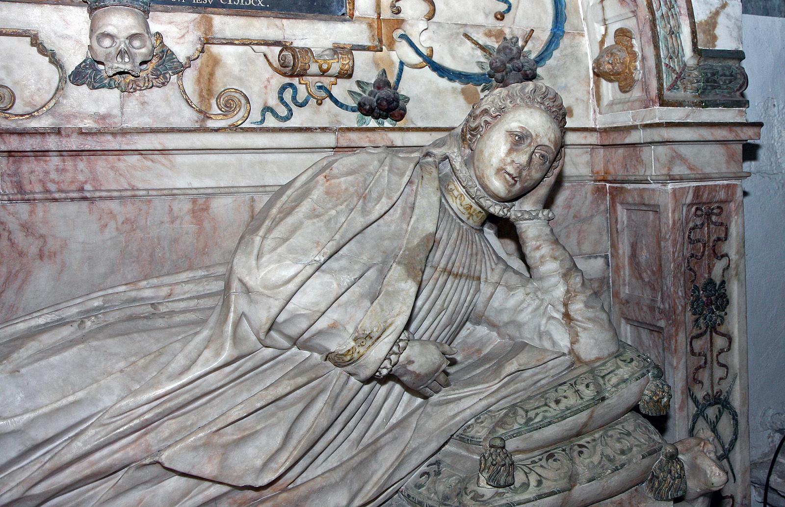 a marble statue of a lady sitting on a floor