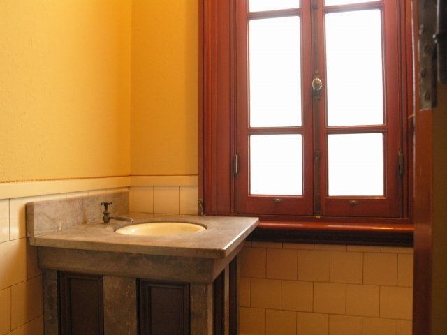 a bathroom with tiled floors and yellow walls