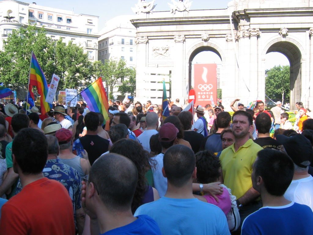 a large crowd of people carrying rainbow flags