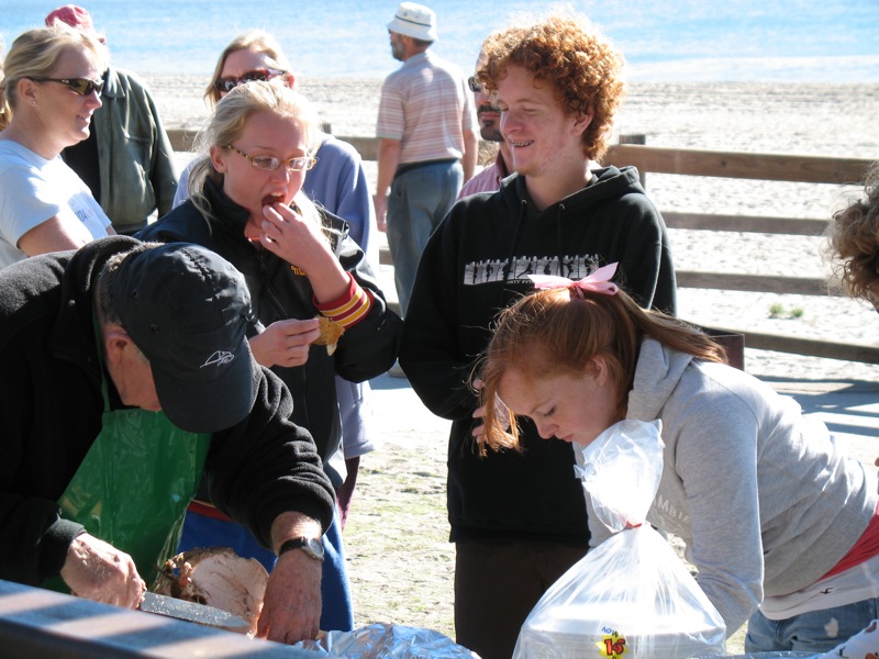 a group of people eating food at an outdoor buffet