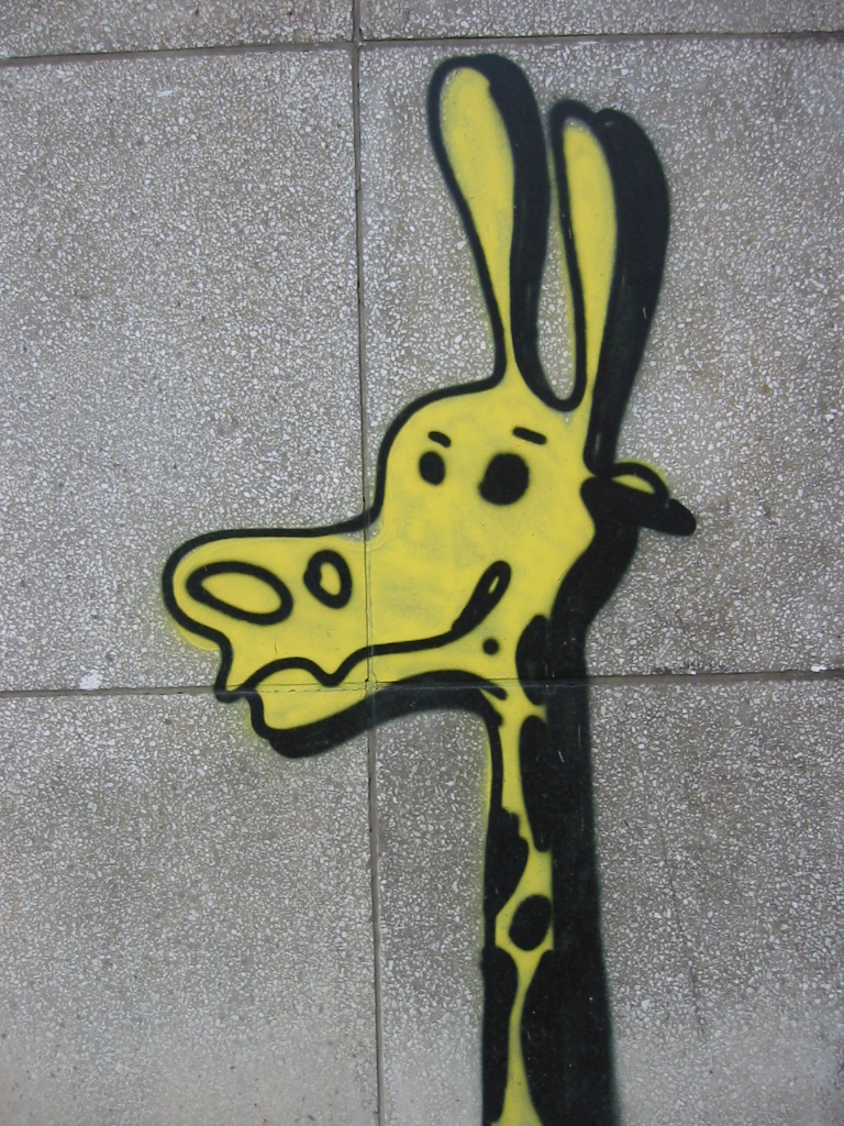 a giraffe that has been stenciled to the concrete