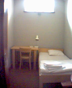 a white bed room with a small table and a bed