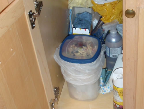 a very cluttered and dirty kitchen drawer with many items on the bottom shelf