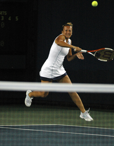 woman wearing blue skirt about to hit a ball with her racket