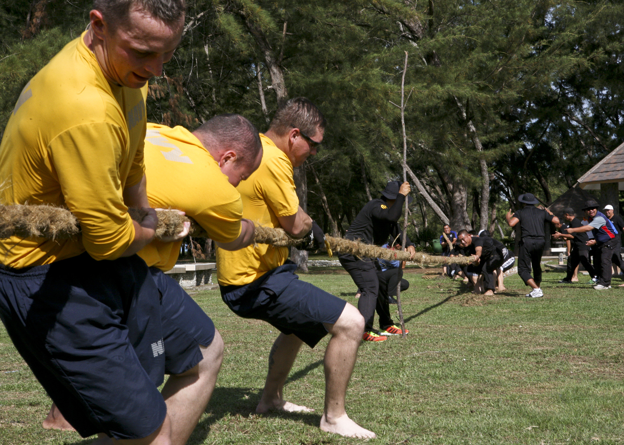 a group of men playing tugo in a park