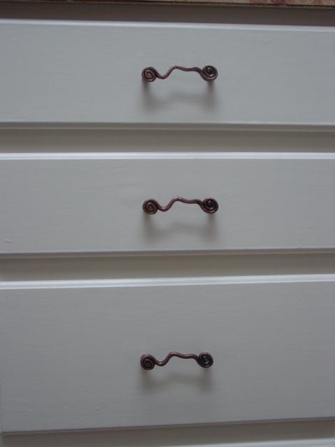 a dresser has two handles and is painted white