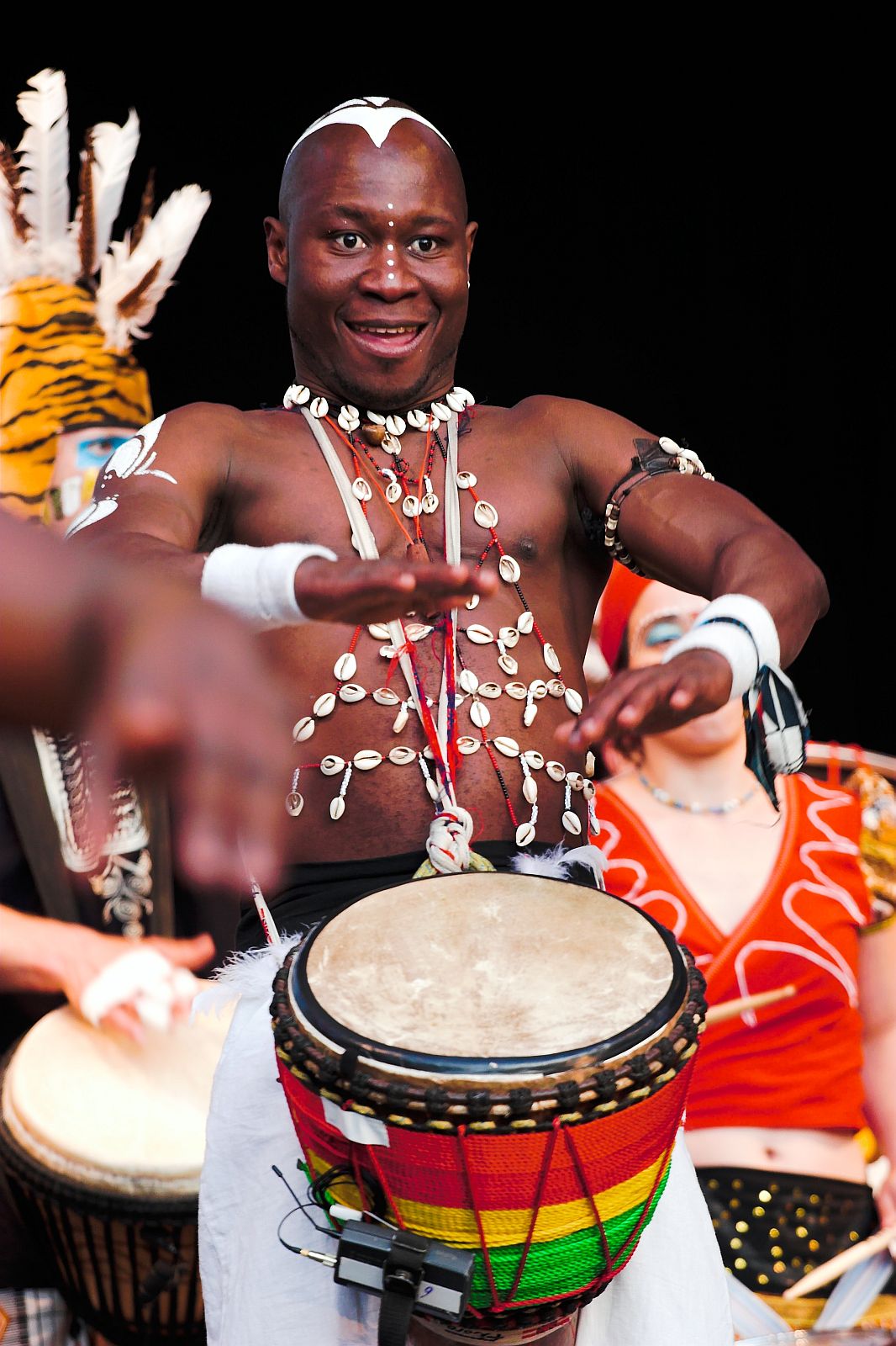 a man in white with a drum near people