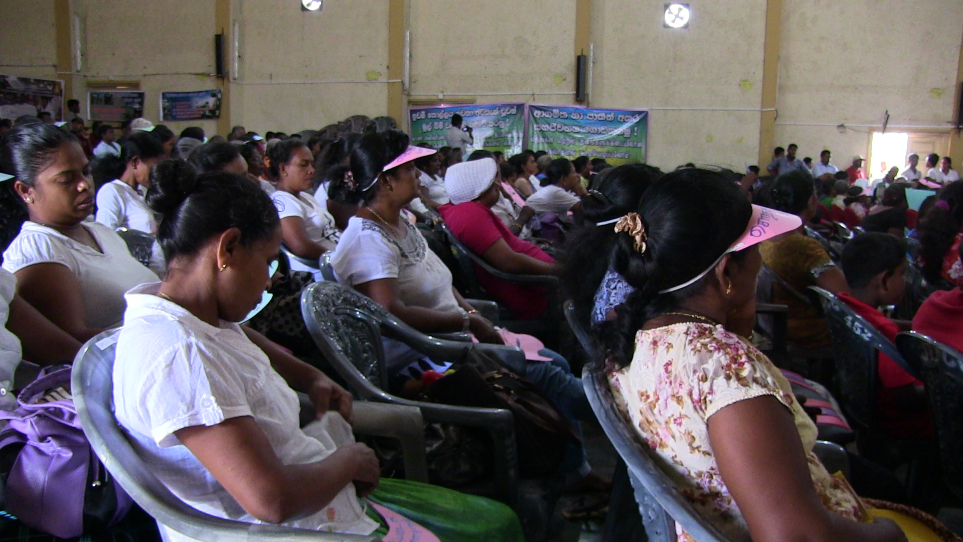 people in a large room, sitting in chairs