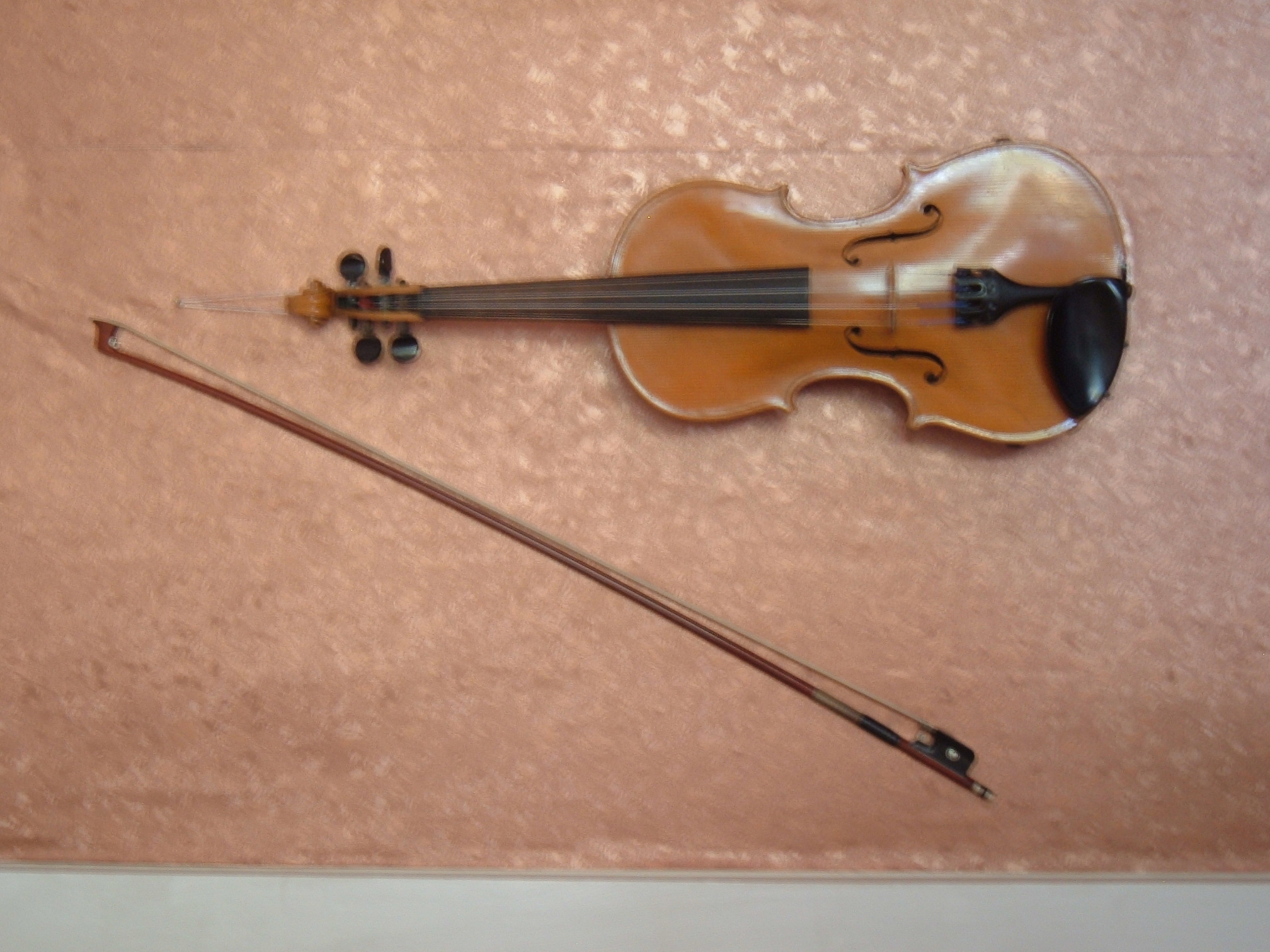 a violin and a bow on a brown table