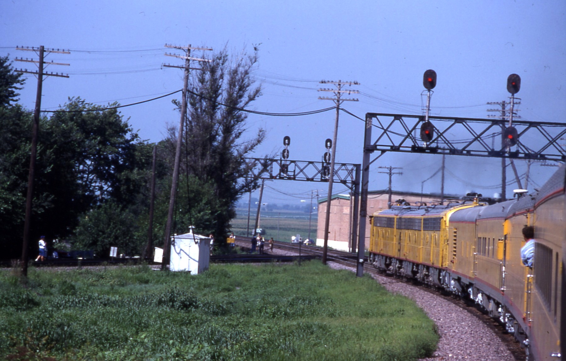 a train moving along the tracks, with power lines and utility poles