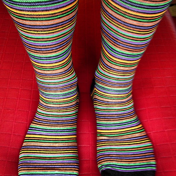 a woman is sitting down with colored socks