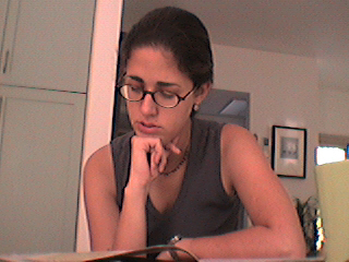a woman with glasses looking at her computer