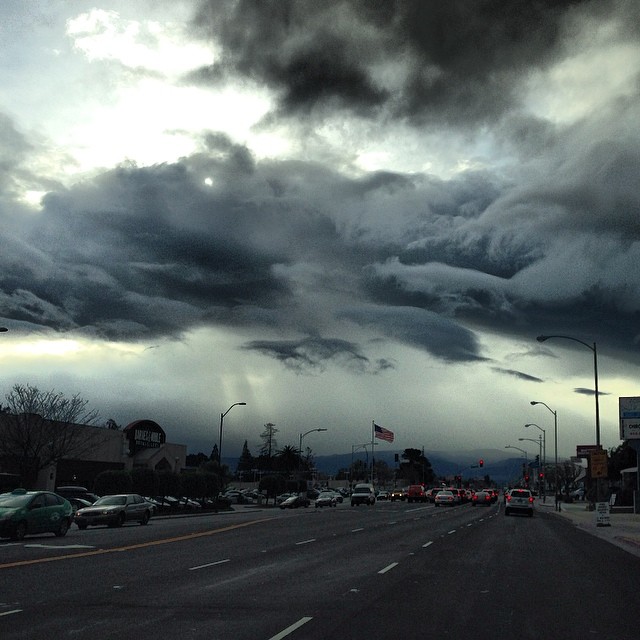 a dark cloud moves into the sky above an intersection