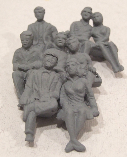 some little grey figurines are sitting on a surface