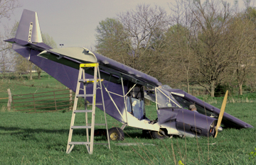 a broken down airplane sitting in a field