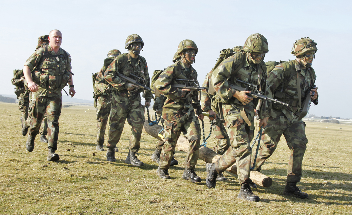 military men in camouflage holding wooden logs