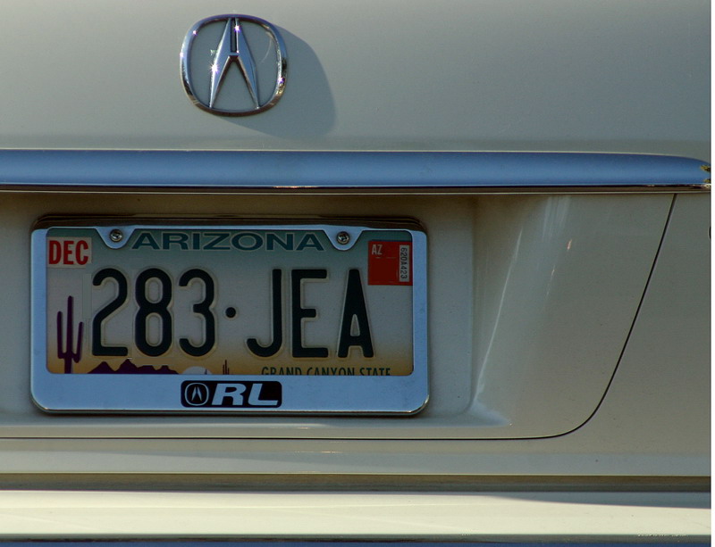 a chrome license plate mounted on the rear of an acura