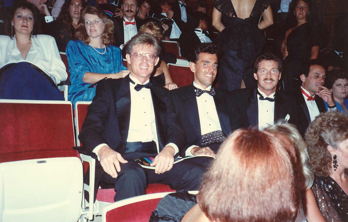 people in suits sitting in auditorium waiting for awards