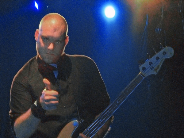 the man is wearing a tie and holding a bass