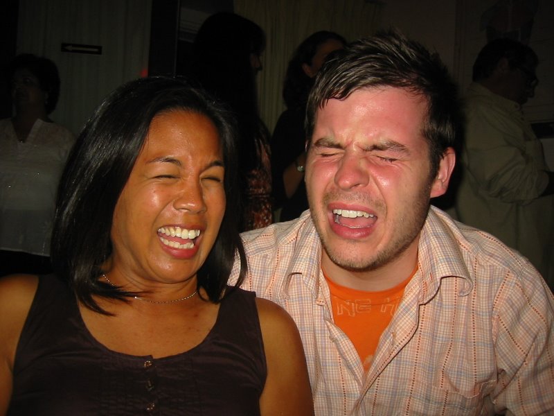 man and woman smiling for camera with head in hands