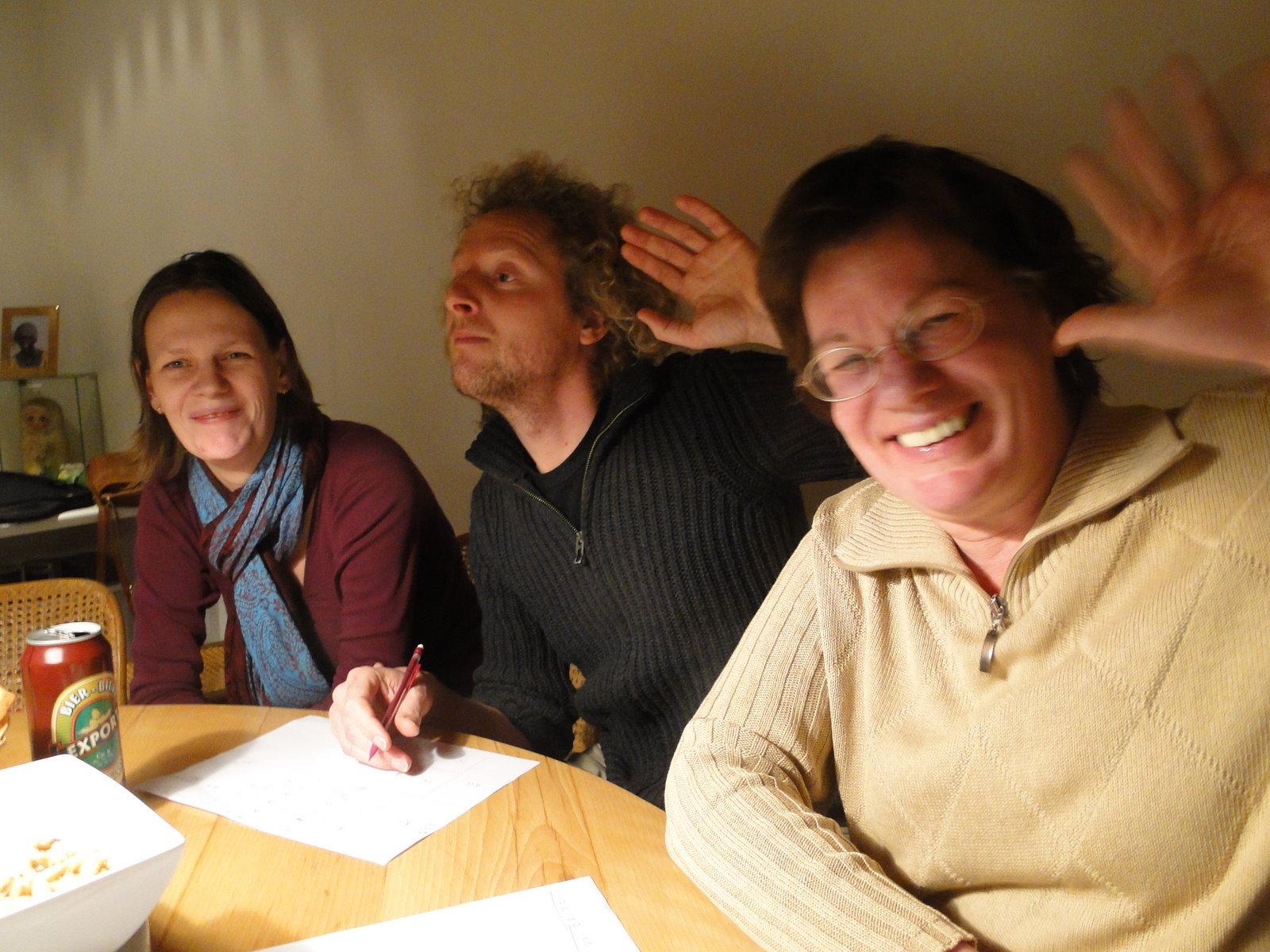 three people are sitting at a table laughing together