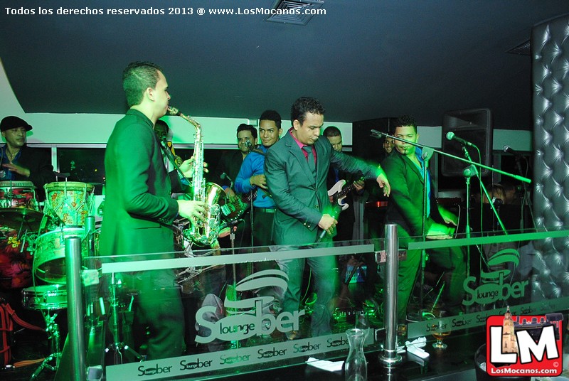 a group of men singing on stage with music equipment