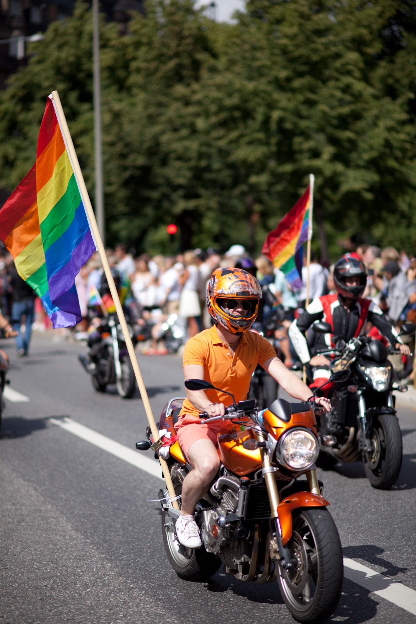 a group of people riding motorcycles holding flags