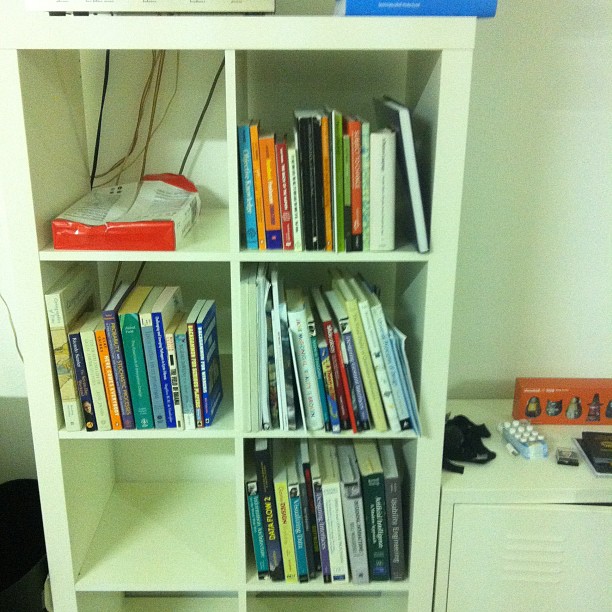 a book shelf with some books and a remote control