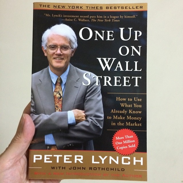 a person holding up a paperback book about wall street