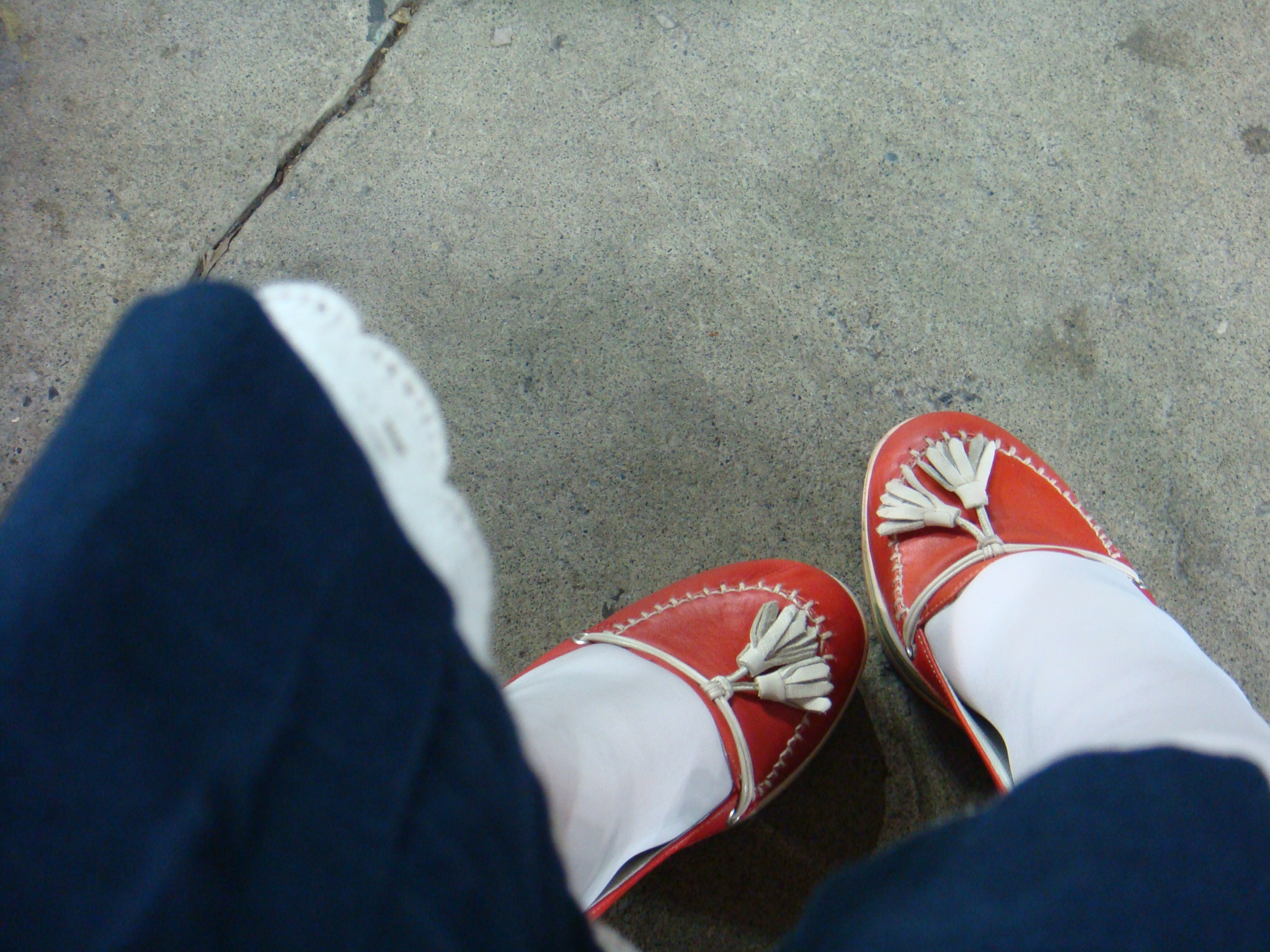 a close up of someone wearing bright red shoes