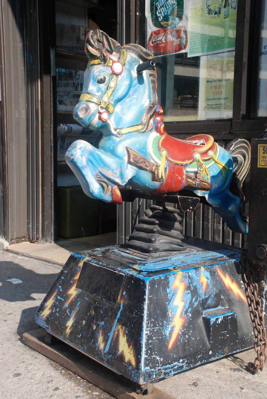 a colorful statue sitting next to a store front