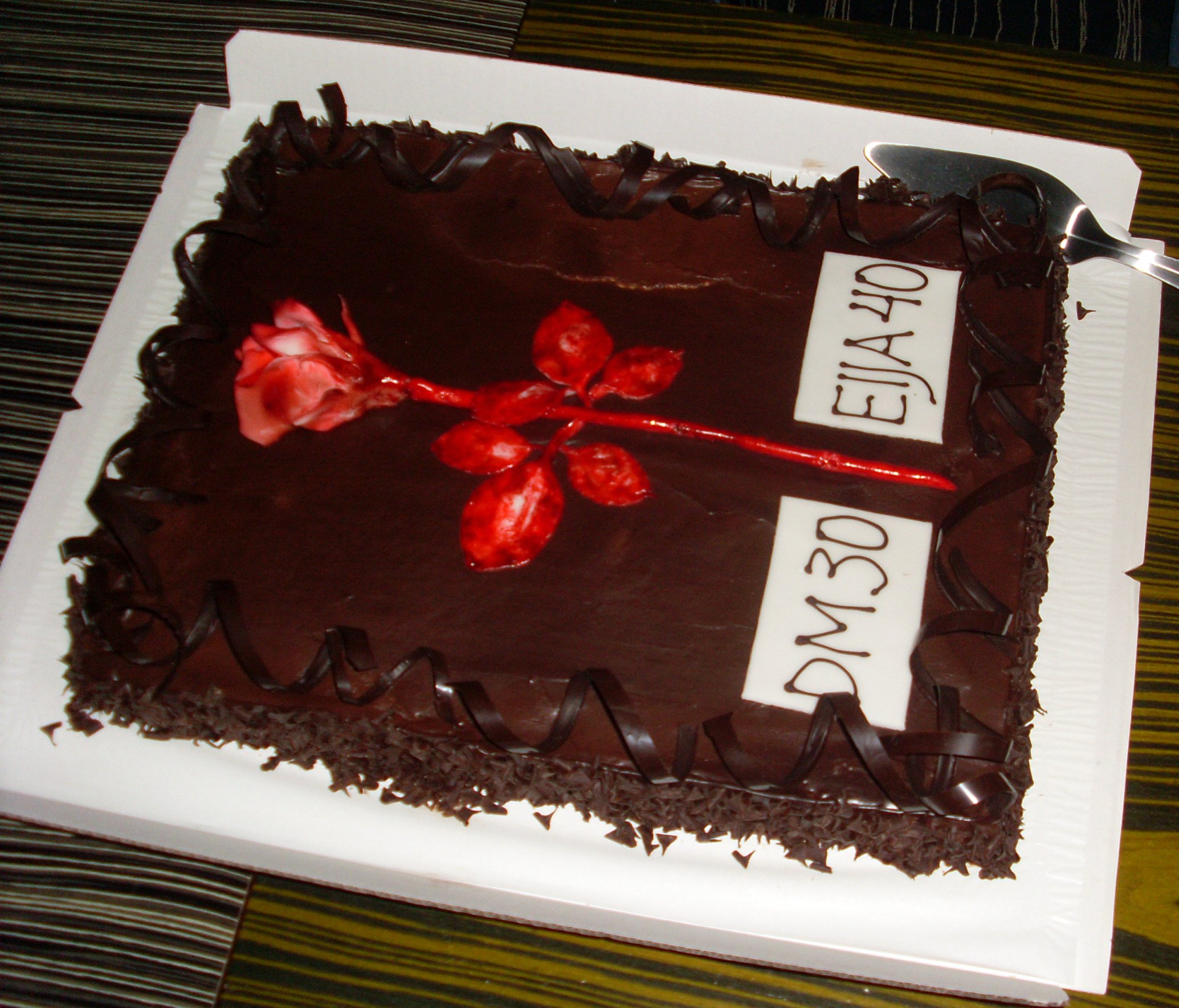 a large chocolate cake with a knife and some writing on it