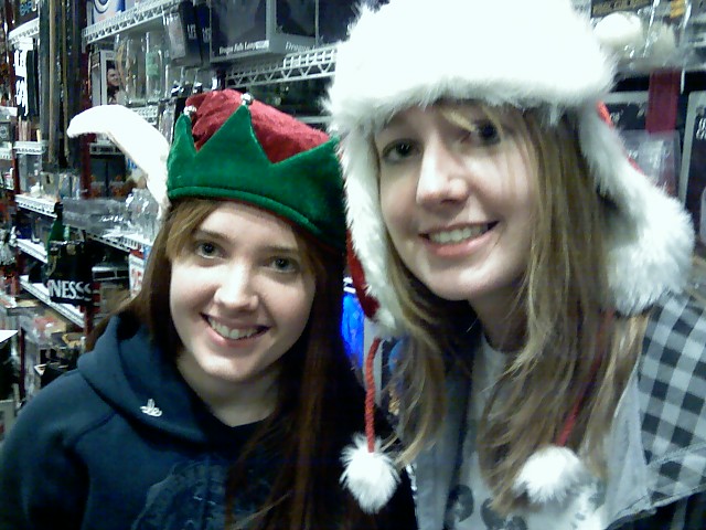 two young women wearing christmas hats in the store