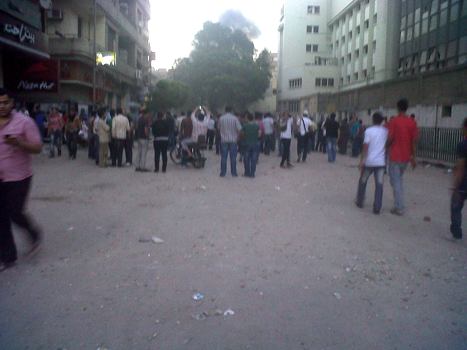 a crowd of people walk around in an alley