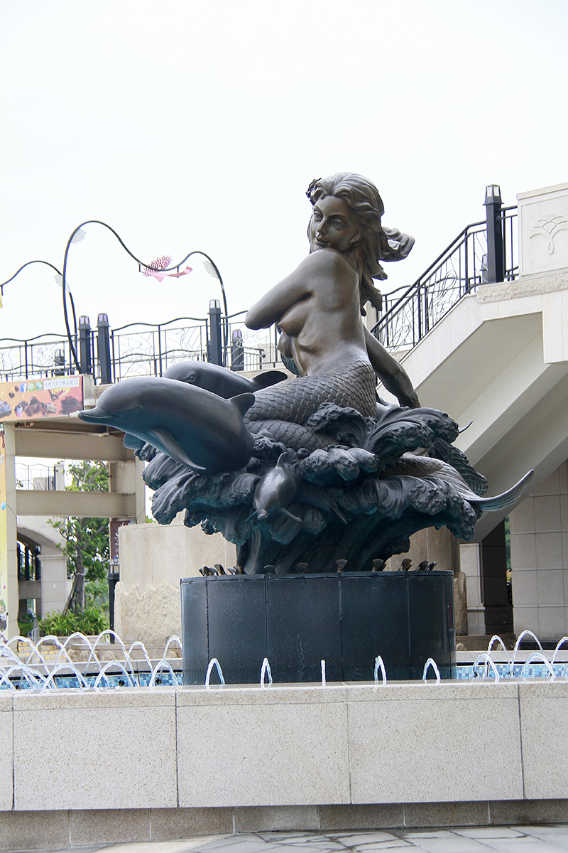 a bronze statue in a fountain surrounded by fountains