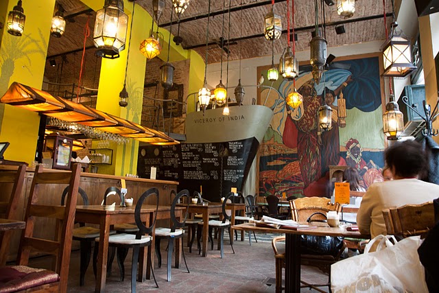 a restaurant with tables and chairs next to a giant mural