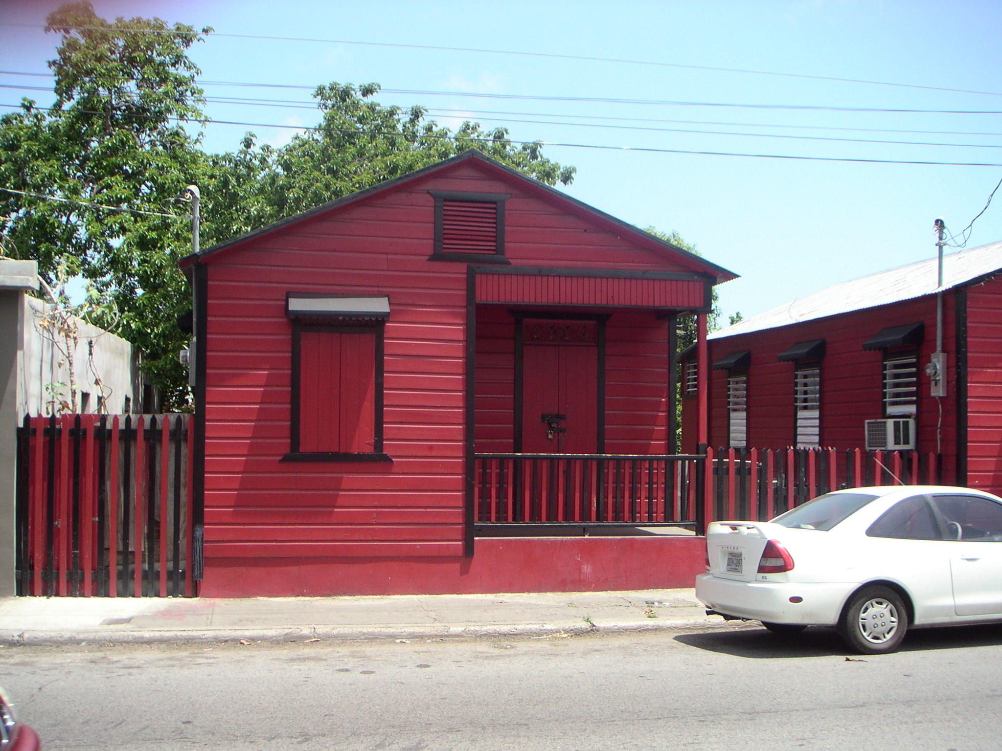 a small red house with a white car parked next to it