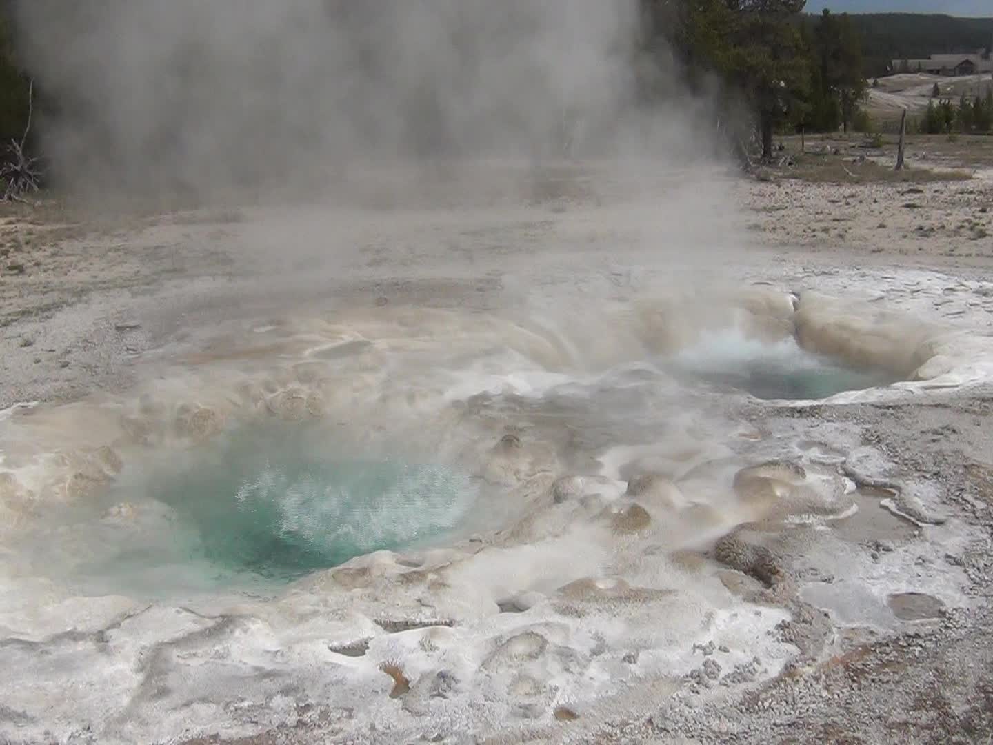 several steaming vents, in the middle of an open - field