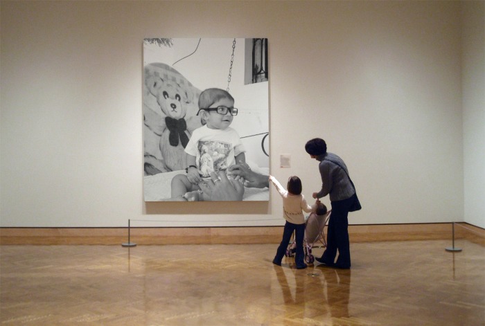 a family looking at artwork in a museum gallery